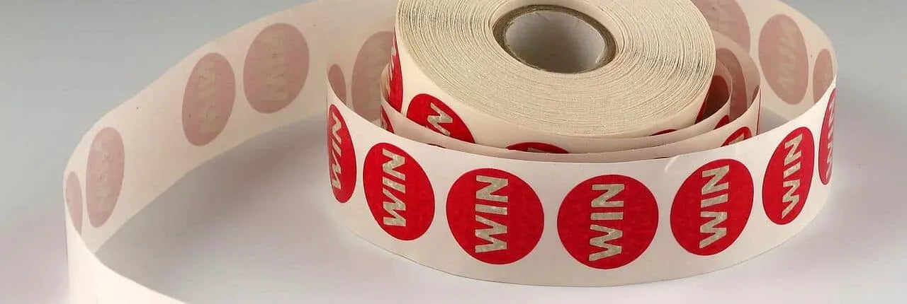 Roll of red and white labels with 'WIN' branding on a light gray background